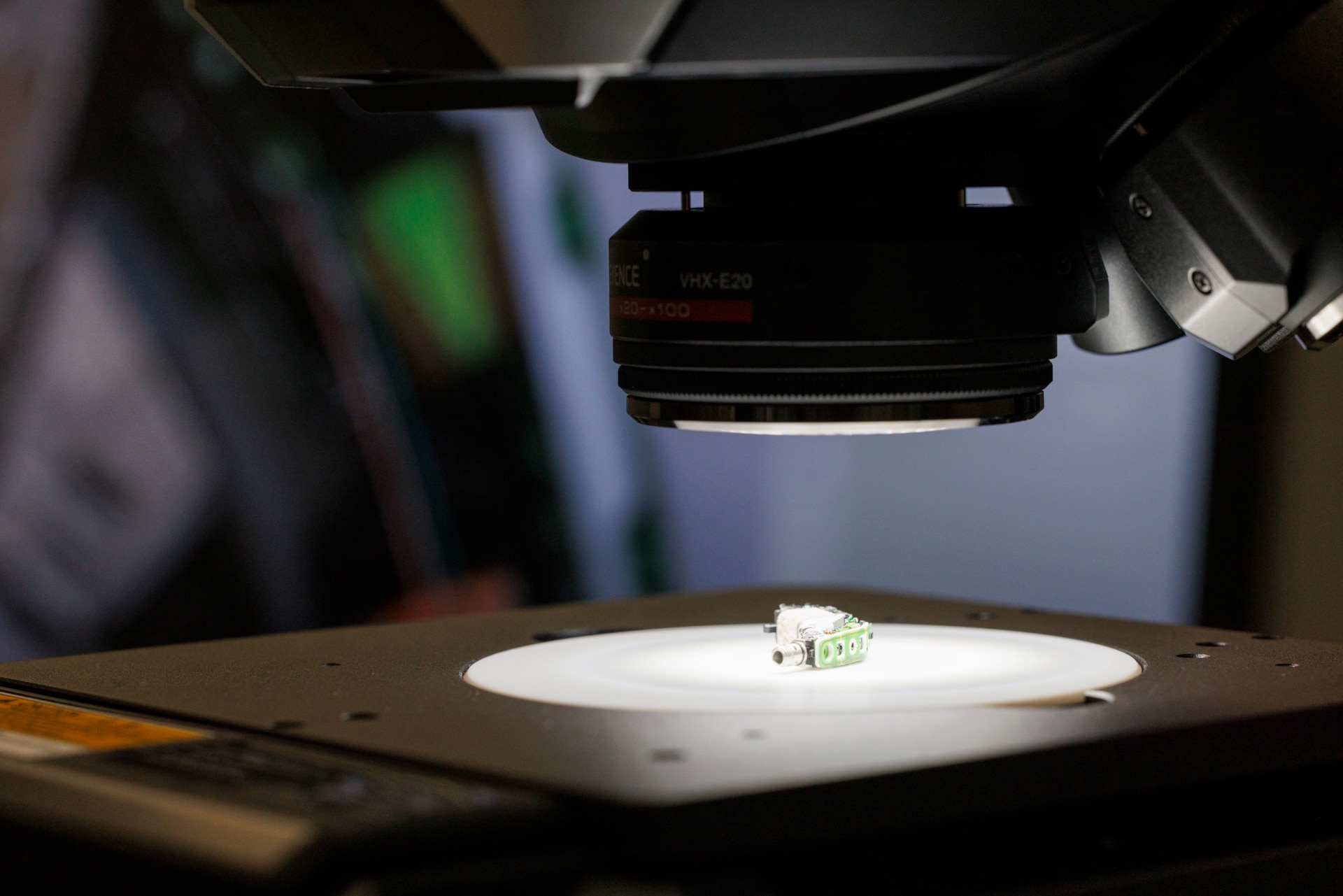A close up of a hearing aid's part under a microscope Un gros plan sur une pièce d’aide auditive sous un microscope