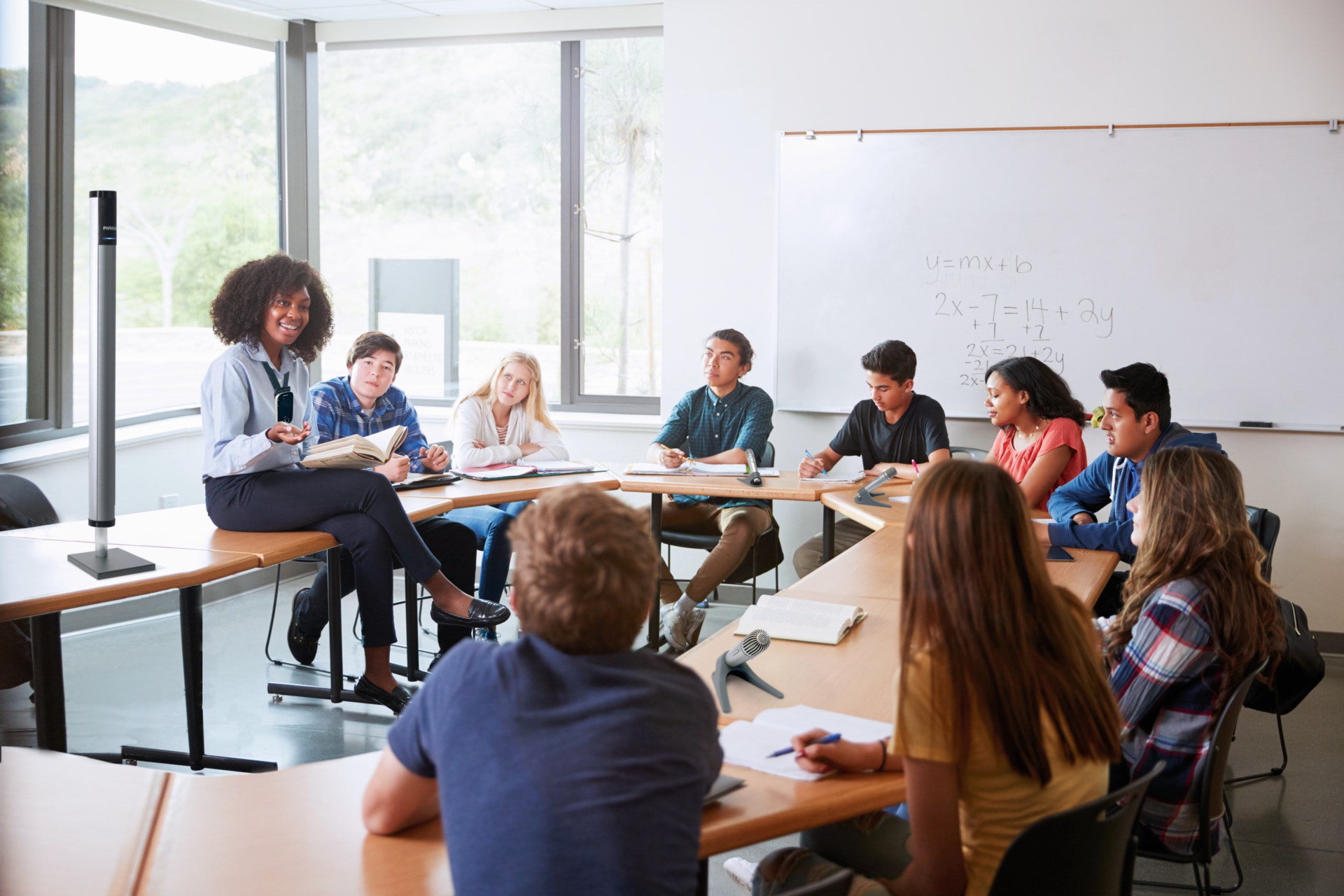 Classroom with nine teenager pupils and a female teacher with plenty of different Phonak Roger microphones.