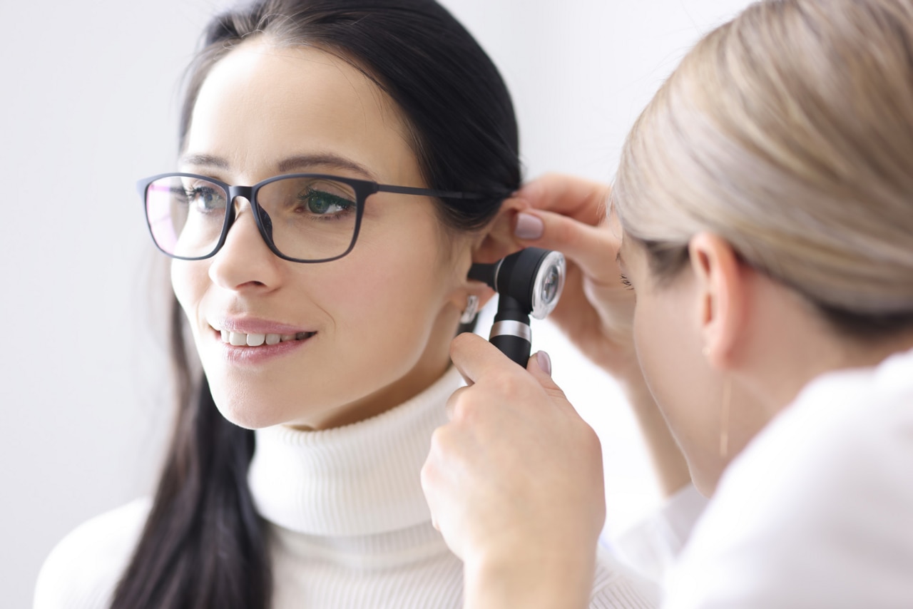 Doctor conducts examinations of ear area for woman; Shutterstock ID 1953551941; purchase_order: -; job: -; client: -; other: -