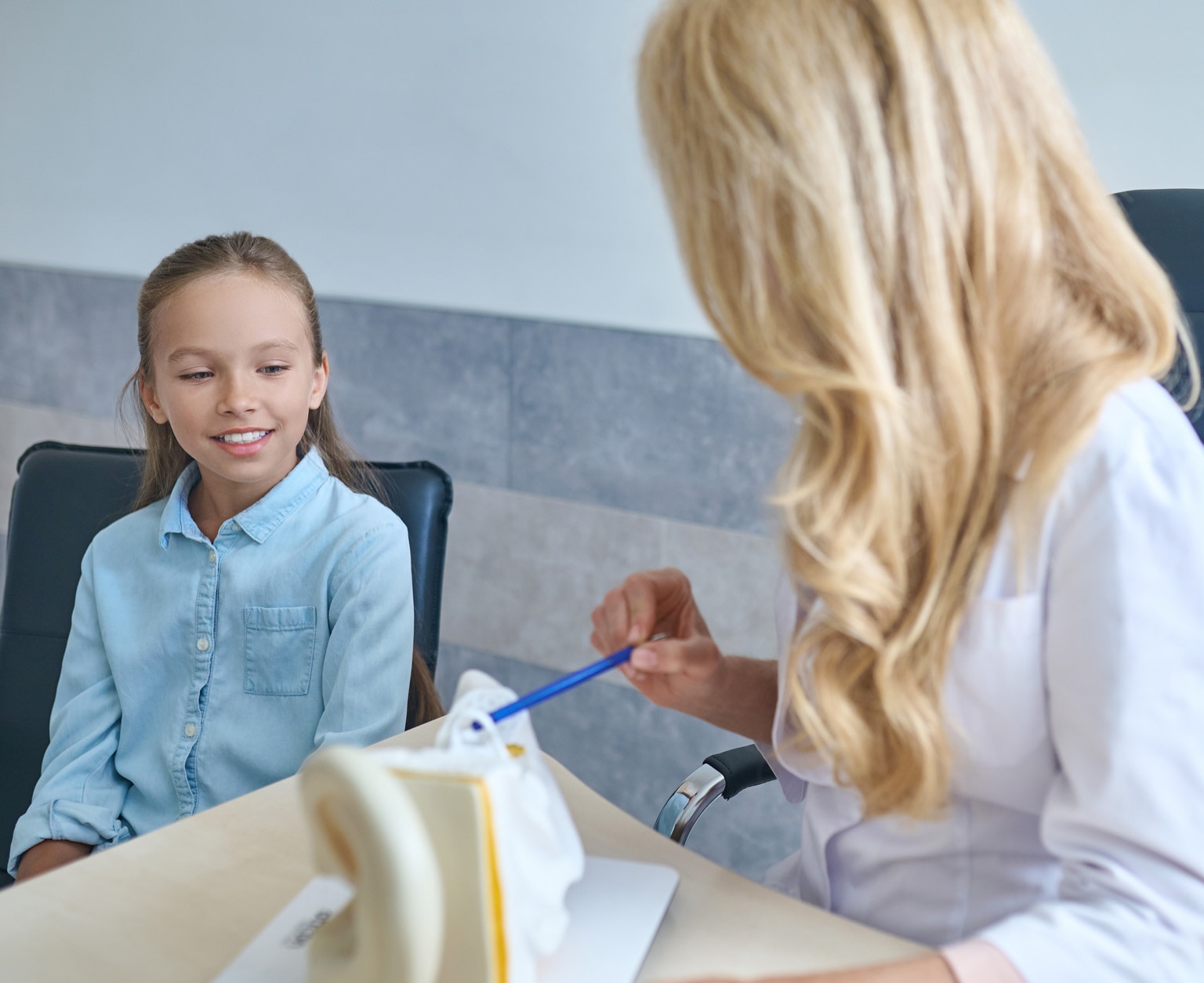 Young female patient being explained the human ear anatomy; Shutterstock ID 2033525255; purchase_order: -; job: -; client: -; other: -