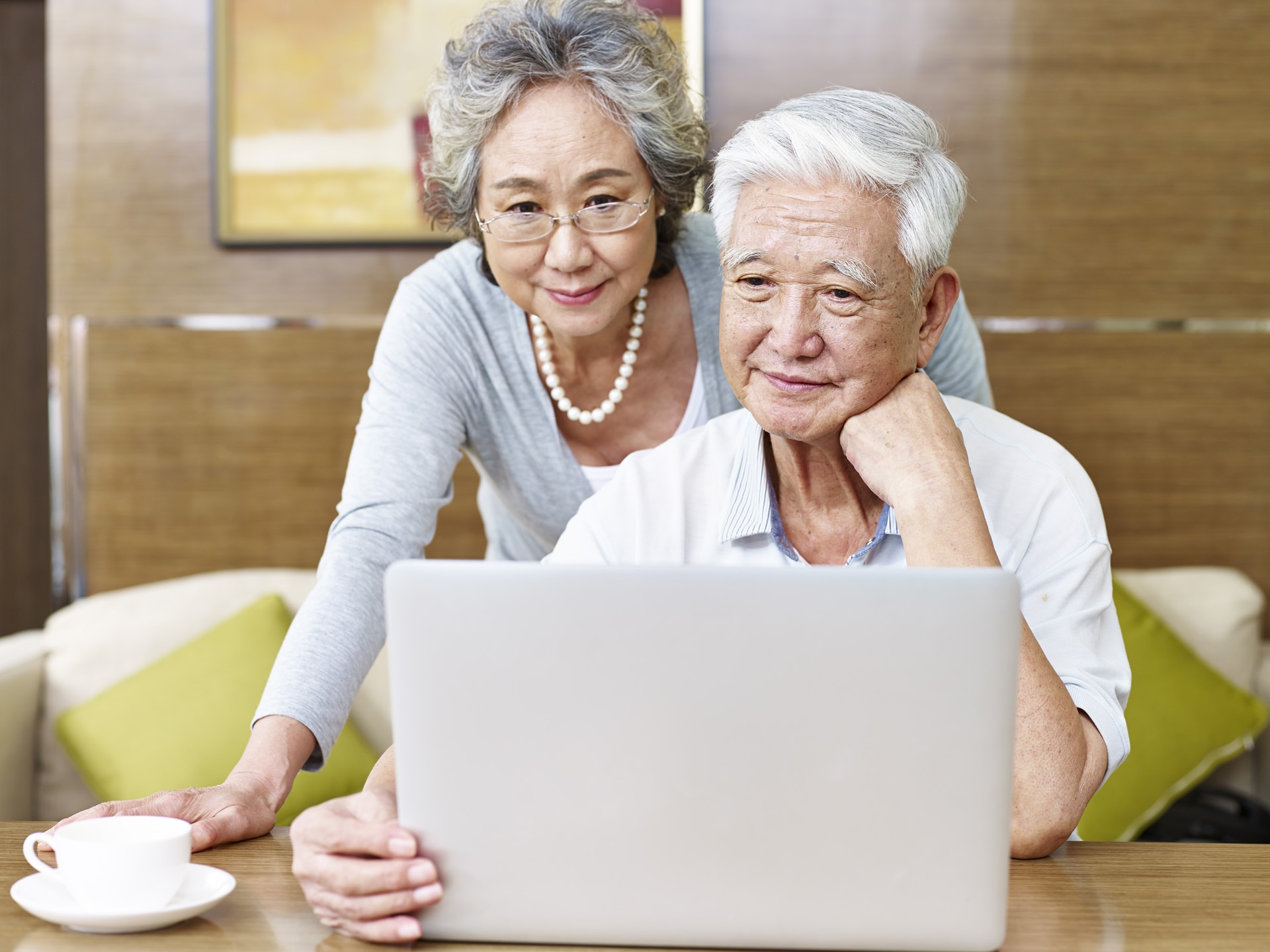 Couple de personnes asiatiques âgées aimantes qui utilisent un ordinateur ensemble.