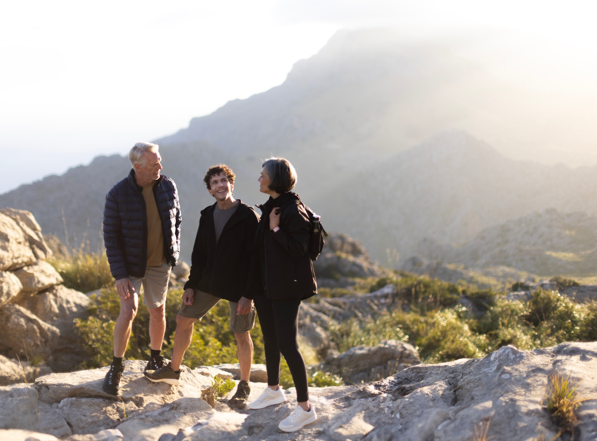 Two man and a women on a mountain talking