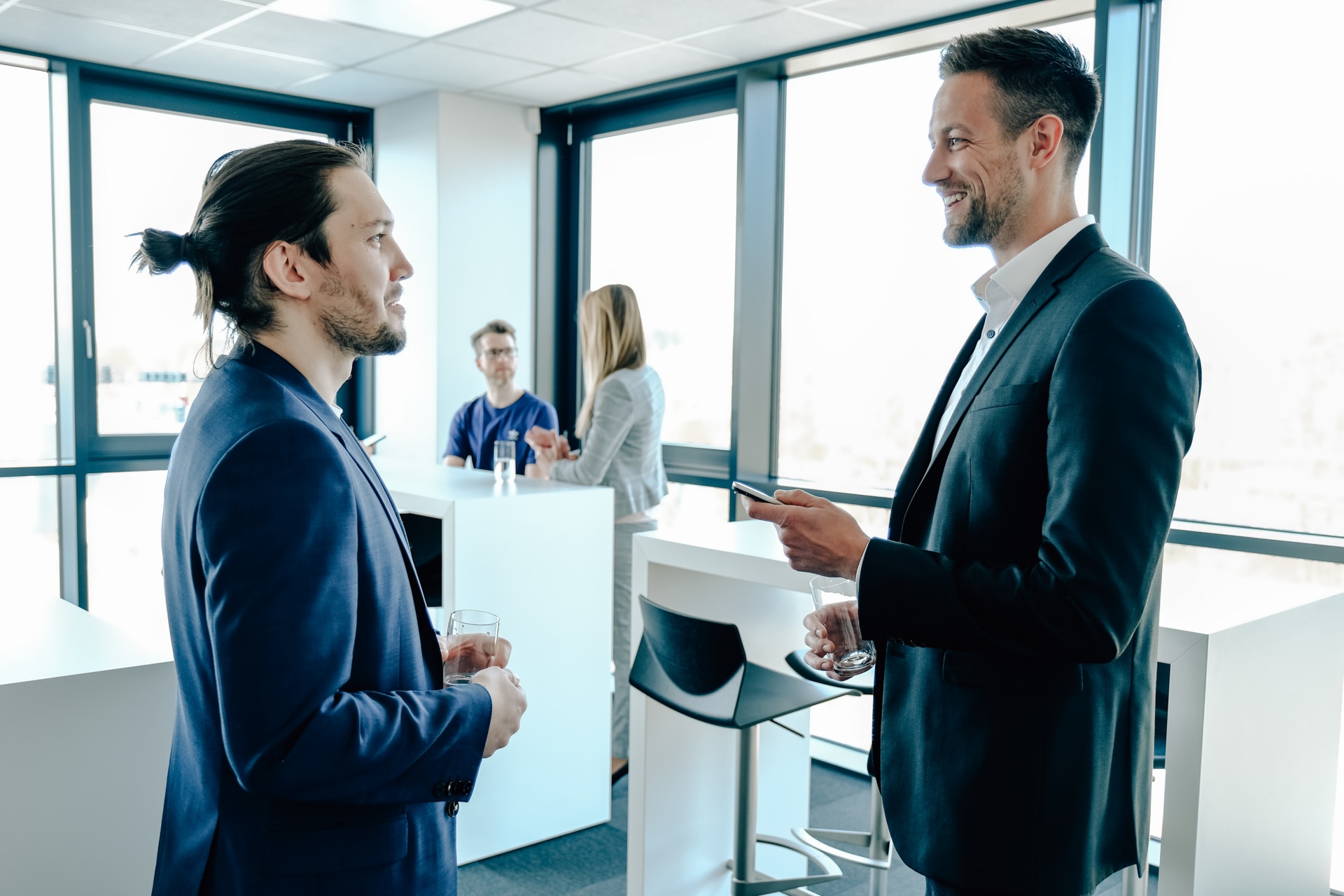 Two male office workers having conversation in an office canteen.