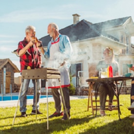 Bloom Beyond Hearing Loss Myths Elderly neighbors having backyard barbecue party