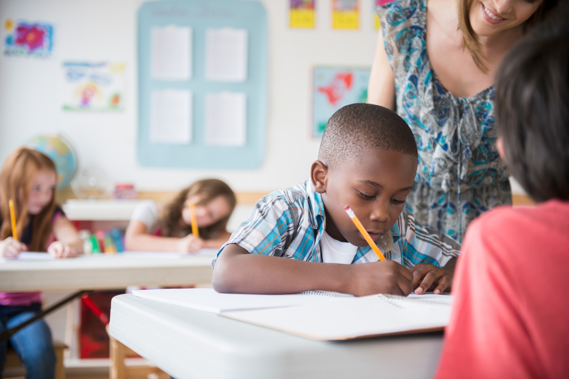Children and female teacher in a classroom. Children and female teacher in a classroom.